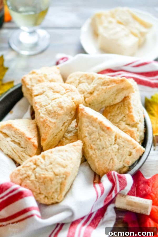 A pan full of white cheddar scones with a glass of wine in the background