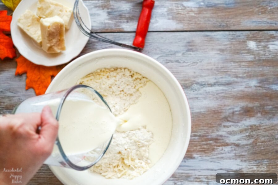 Heavy cream and a whisked egg are added to the dry ingredients and grated butter mixture
