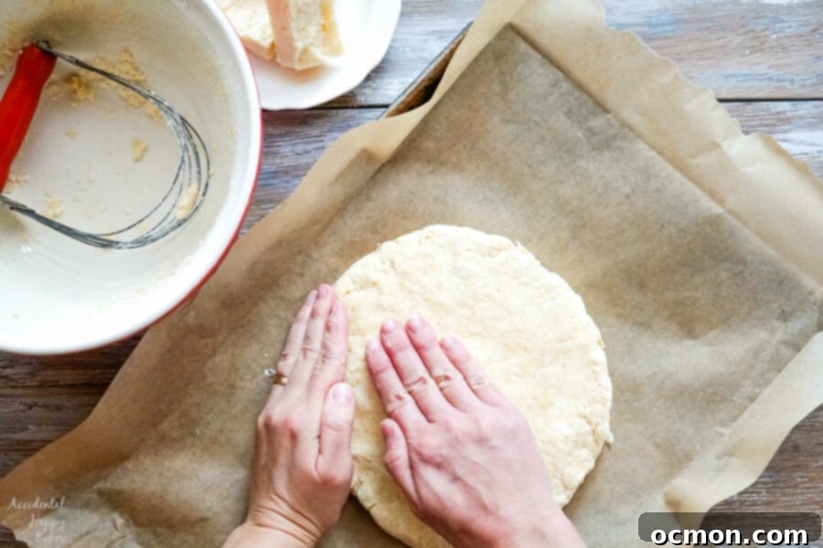 Scone dough shaped into a uniform 8-inch round on a parchment-lined baking sheet