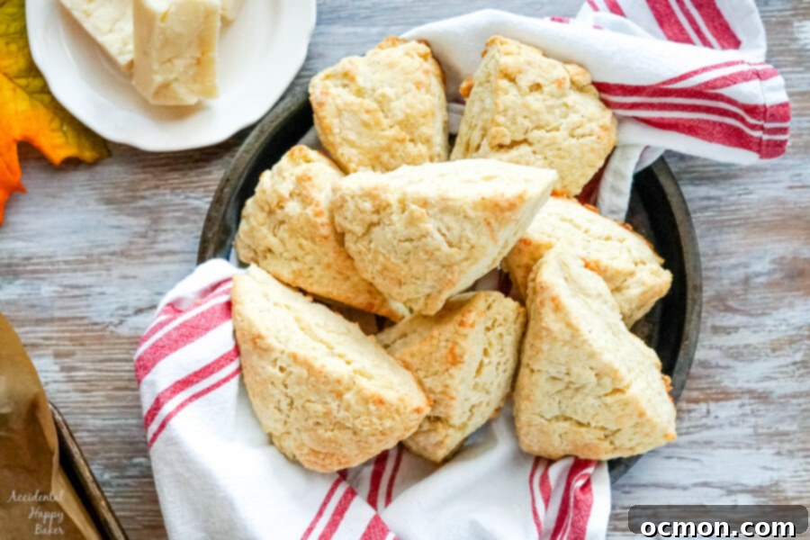 A bowl filled with warm, golden brown white cheddar scones, fresh from the oven
