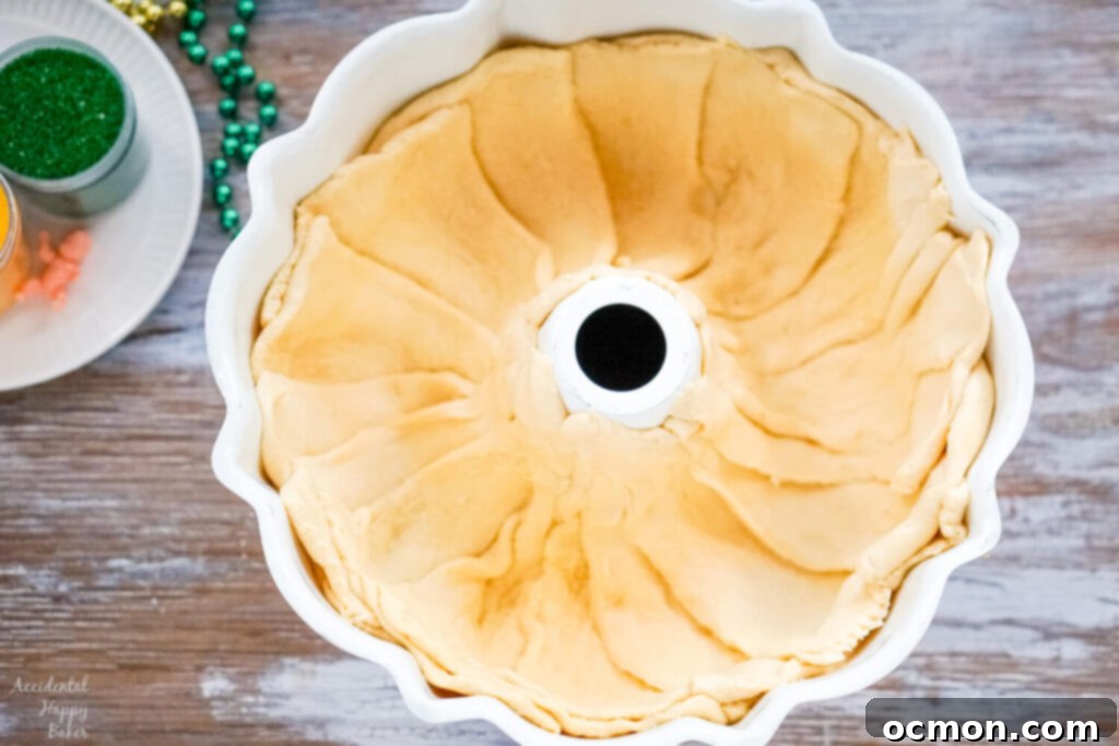 Crescent rolls are pressed into a bundt pan. 