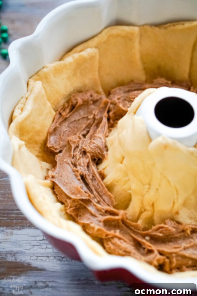 Cinnamon filling is spooned into the crescent rolls. 