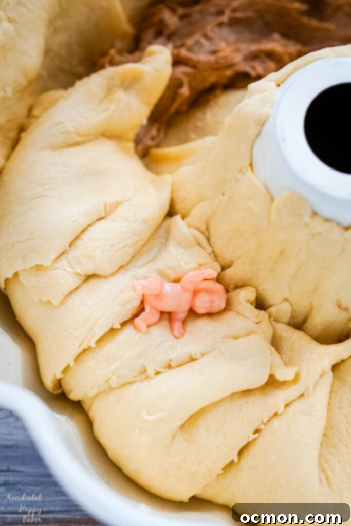 The crescent rolls are folded over the filling and the baby trinket is tucked between the layers of the rolls. 