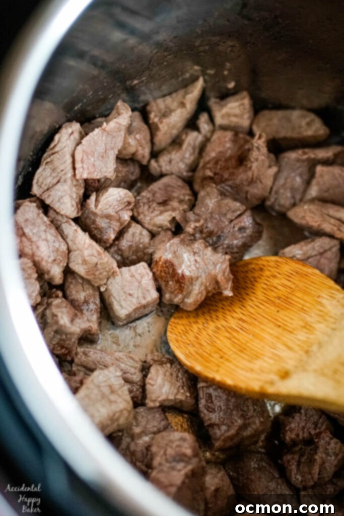 Cubed stew beef is browned in oil in the instant pot. 