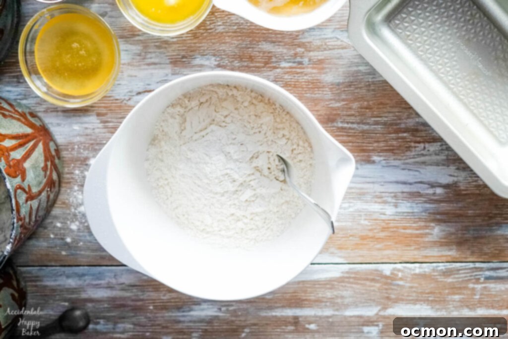 Golden Nectar Loaf 3 A mixing bowl holds all-purpose flour, baking powder, and salt, ready to be combined for the honey beer bread recipe.