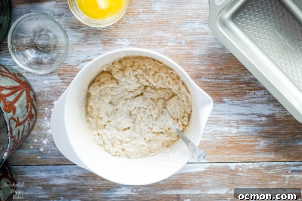 Golden Nectar Loaf 5 The honey beer bread batter, a shaggy mixture of wet and dry ingredients, is gently stirred in a bowl until just combined, ensuring no dry flour streaks remain.