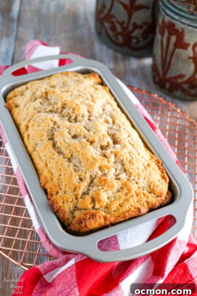 Golden Nectar Loaf 7 A freshly baked loaf of honey beer bread, with a rich golden crust, cools on a wire rack, steam gently rising, awaiting its final buttery glaze.