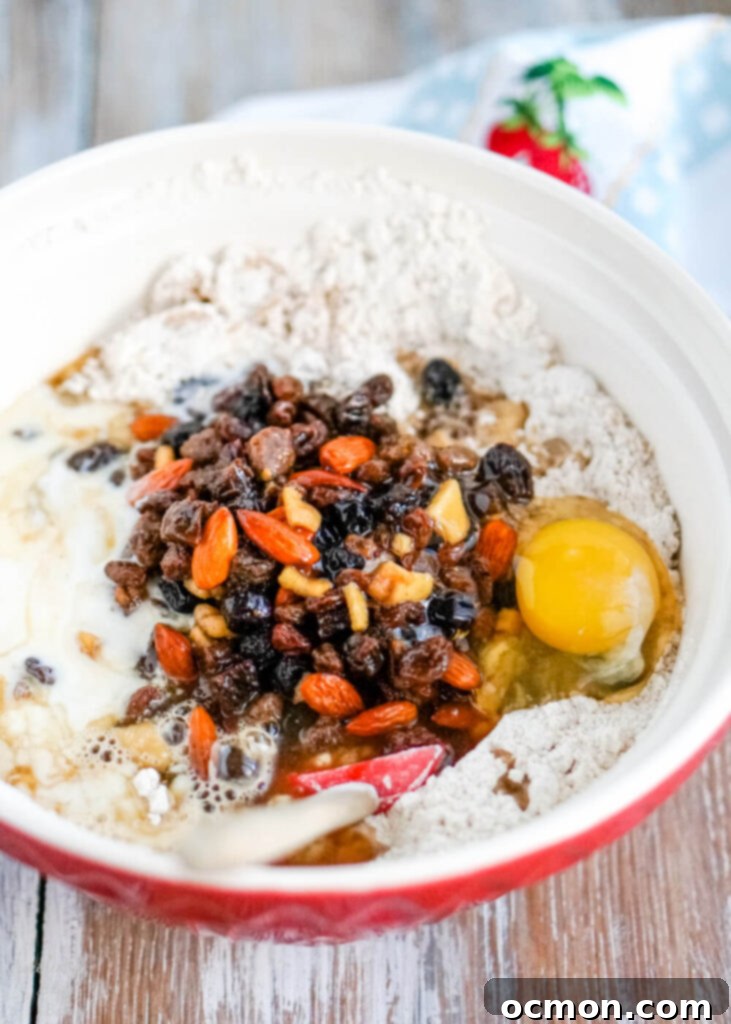 Welsh Bara Brith Tea Bread 7 The cooled tea-infused fruit mixture being combined with self-rising flour, brown sugar, egg, and buttermilk in a large mixing bowl.