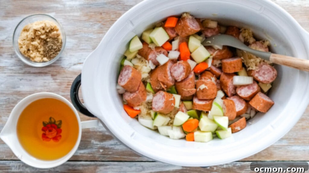Sauerkraut, sliced kielbasa, and chopped veggies are being added to the slow cooker crock.