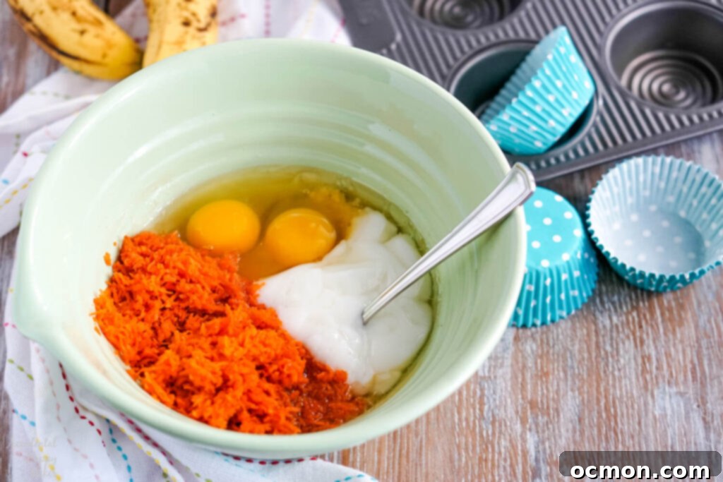 Finely shredded carrots and mashed bananas in a large mixing bowl.