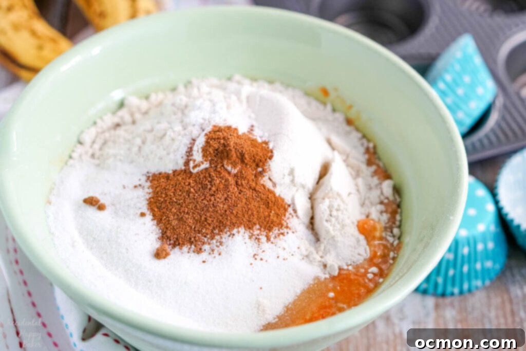 Dry ingredients layered on top of wet ingredients in a mixing bowl.