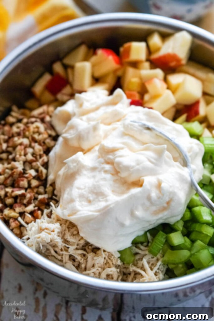 Crisp Apple Pecan Chicken Salad 6 chopped pecans, chopped apples, chopped celery, and mayo in a metal bowl