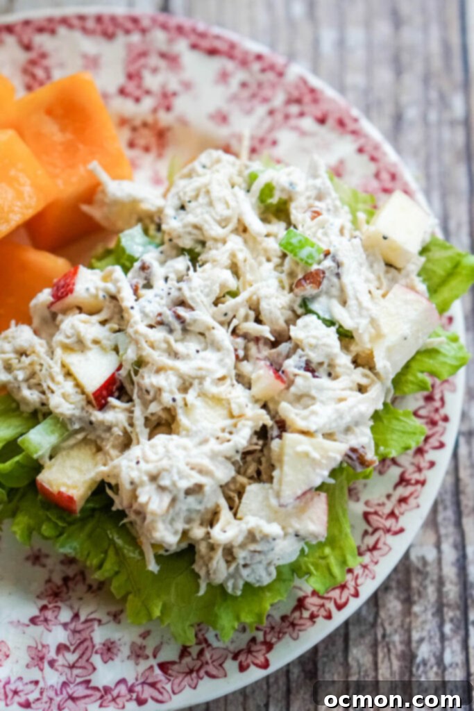 Crisp Apple Pecan Chicken Salad 7 apple pecan chicken salad on a bed of lettuce with fruit on a floral plate