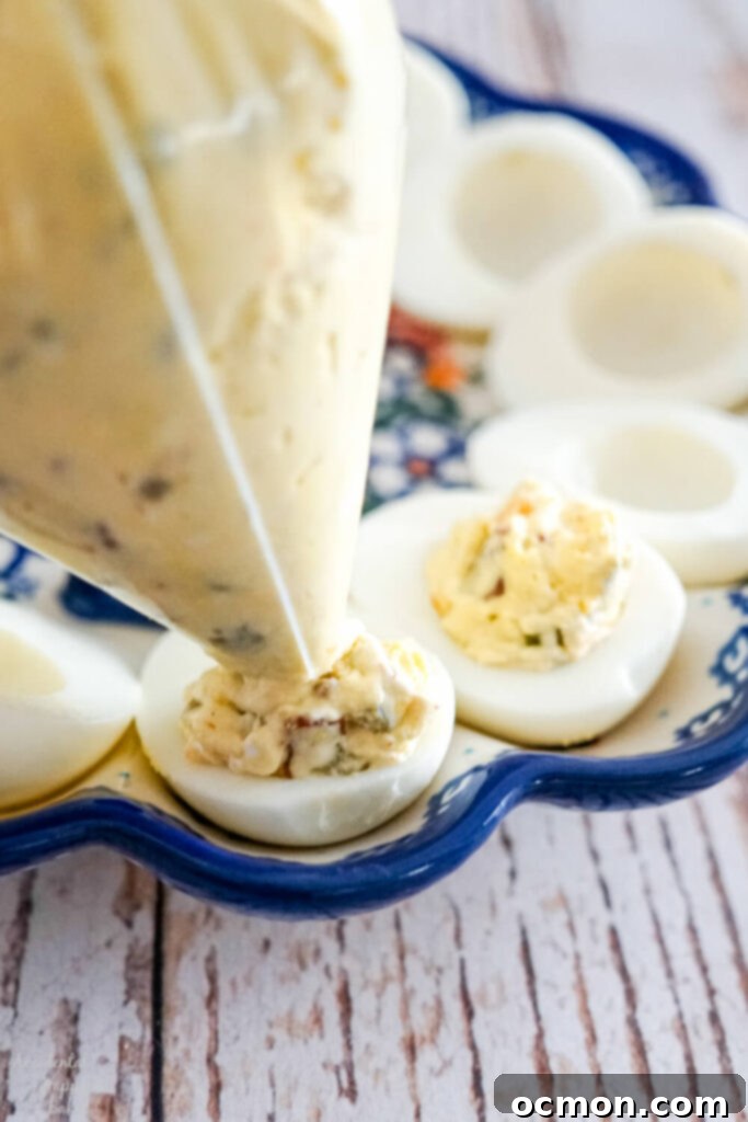 Devilish Jalapeno Poppers 8 The end of the baggie is cut off and the filling is piped into the sliced egg halves.