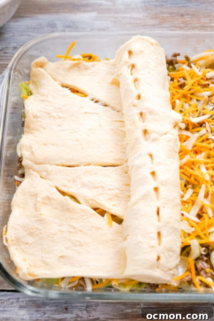 Runza Style Beef and Cabbage Bake 4 Rolling the crescent roll dough over the filling for the Runza casserole