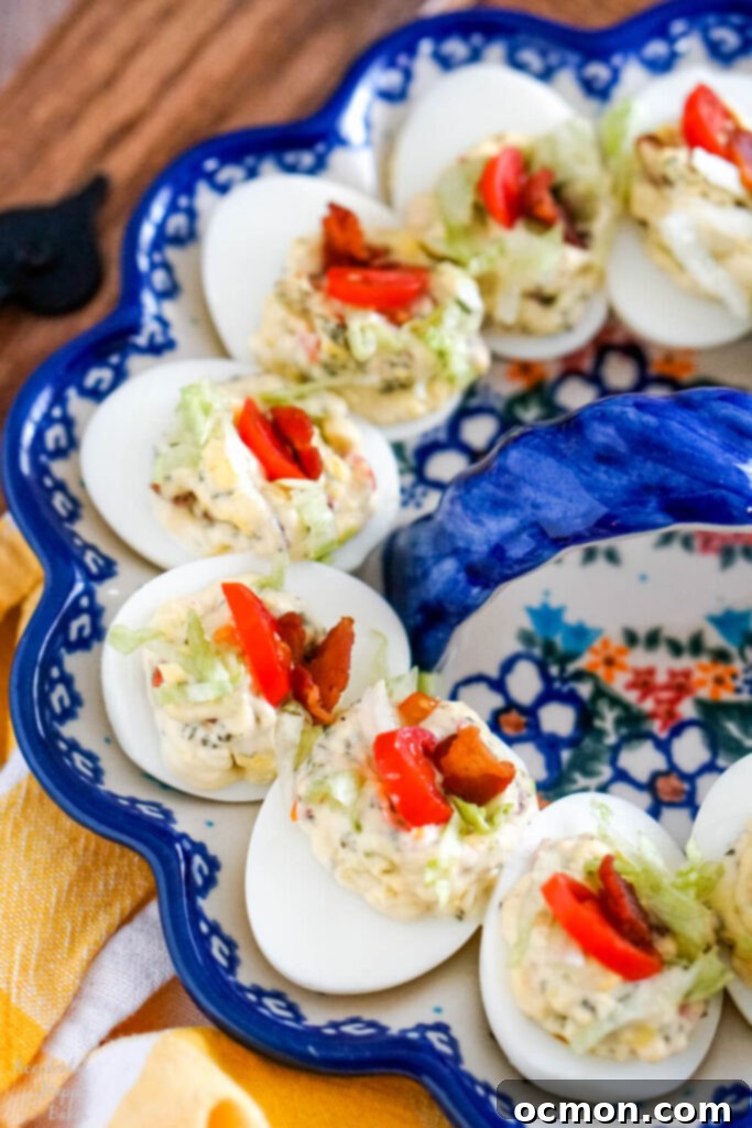 A close up image of BLT deviled eggs arranged on an egg plate. Delicious and visually appealing party food.