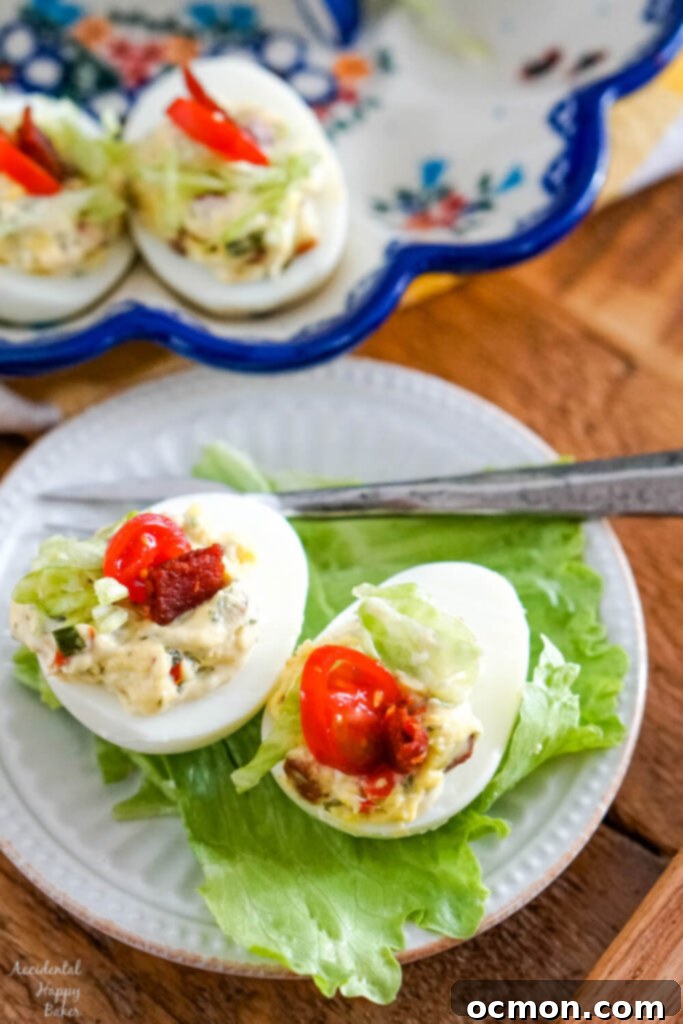 Two BLT deviled eggs on a bed of lettuce, beautifully garnished and ready to be enjoyed.