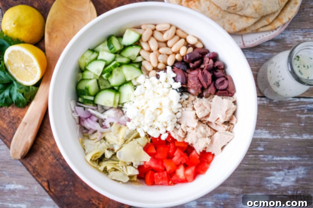All the fresh and canned ingredients for the tuna salad, beautifully arranged in a large serving bowl before mixing, showcasing their vibrant colors.