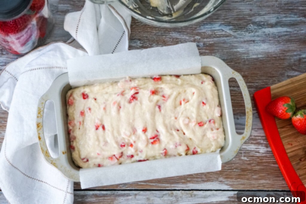 A freshly baked loaf of strawberry bread, golden brown on top, cooling after an hour in the oven, ready for slicing and enjoying.