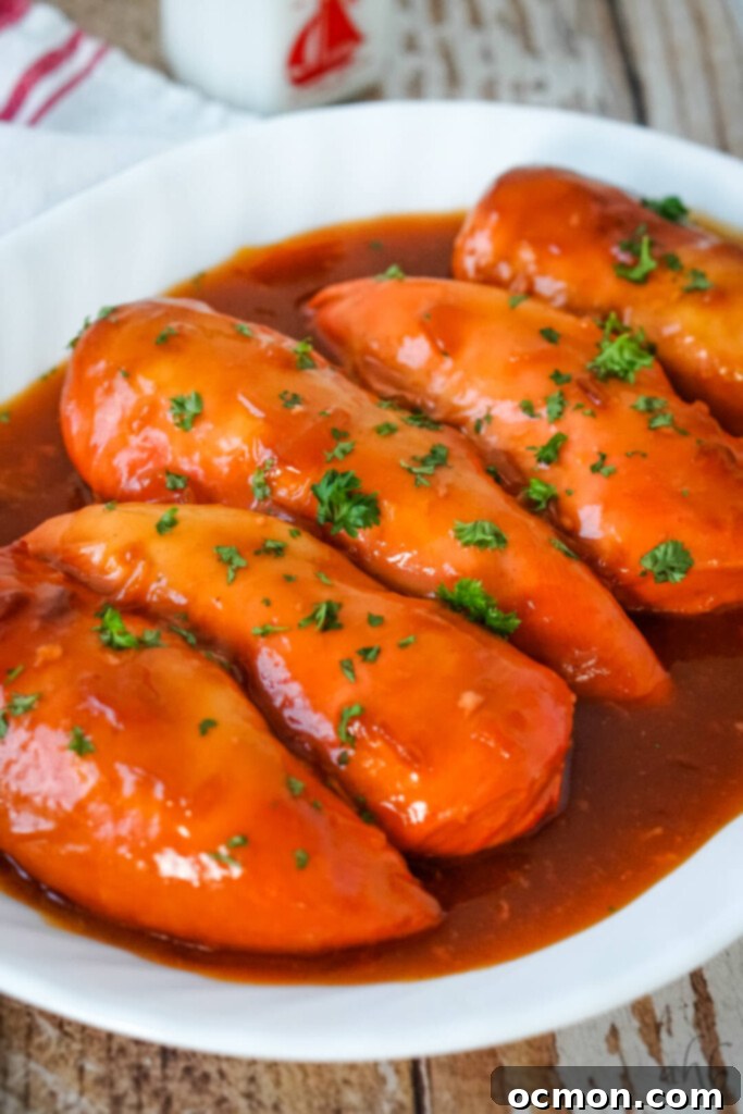 A white platter with several pieces of Catalina Chicken and sauce. 