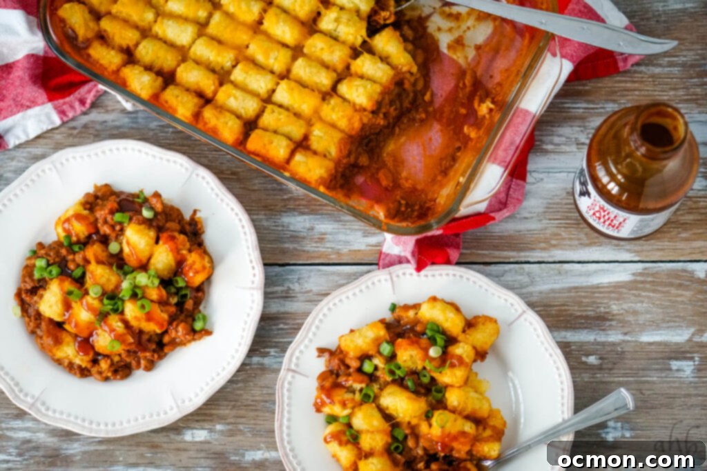 Hearty Pulled Pork Tater Tot Bake 5 A perfectly baked Pulled Pork Tater Tot Casserole, garnished with fresh green onions, showcasing the golden-brown tater tots and bubbling cheese.