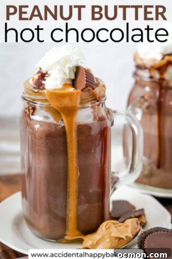Decadent Peanut Butter Hot Chocolate 7 Two mugs of peanut butter hot chocolate, topped with whipped cream and chocolate drizzle, on a cozy wooden surface.