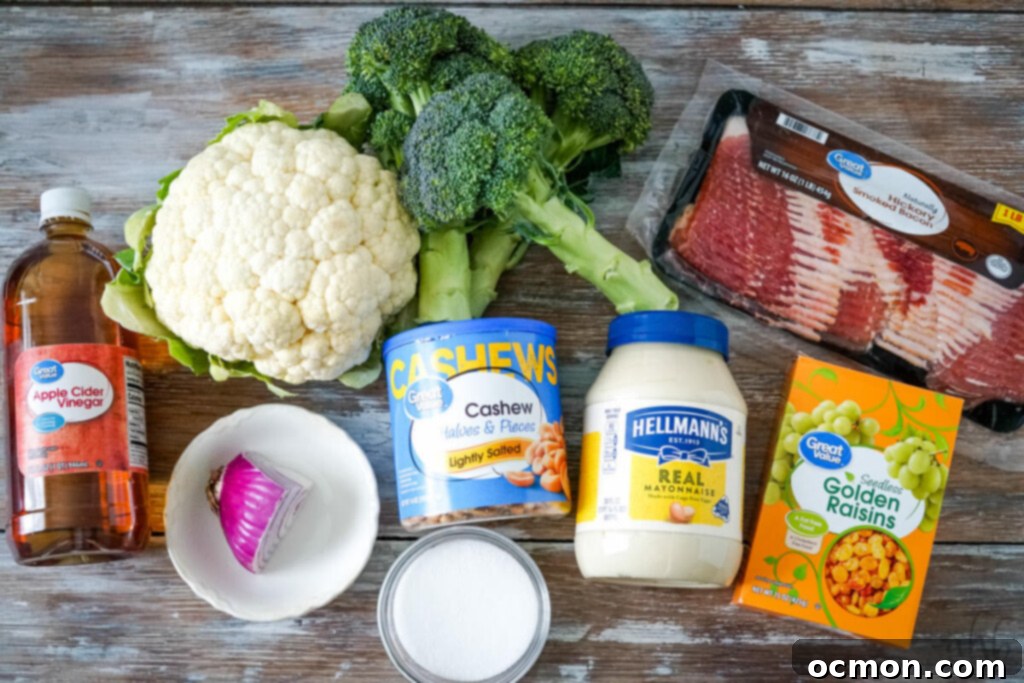 Amish-Style Creamy Broccoli and Cauliflower Salad 3 The vibrant ingredients needed to prepare the Amish Broccoli Cauliflower salad, including fresh broccoli and cauliflower, crispy bacon, sweet golden raisins, crunchy cashews, and the key components for the creamy dressing.