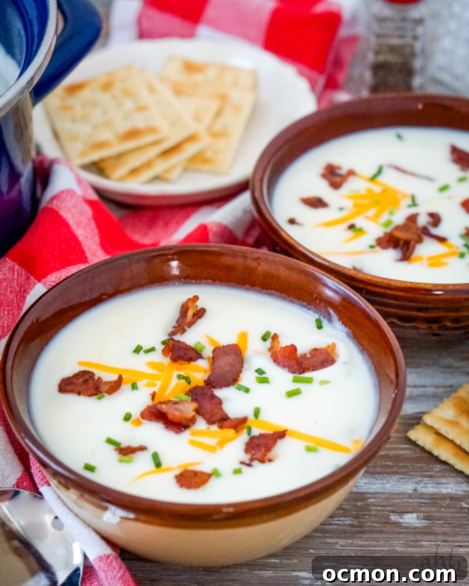Creamy 4 Ingredient Potato Soup in a brown bowl with toppings