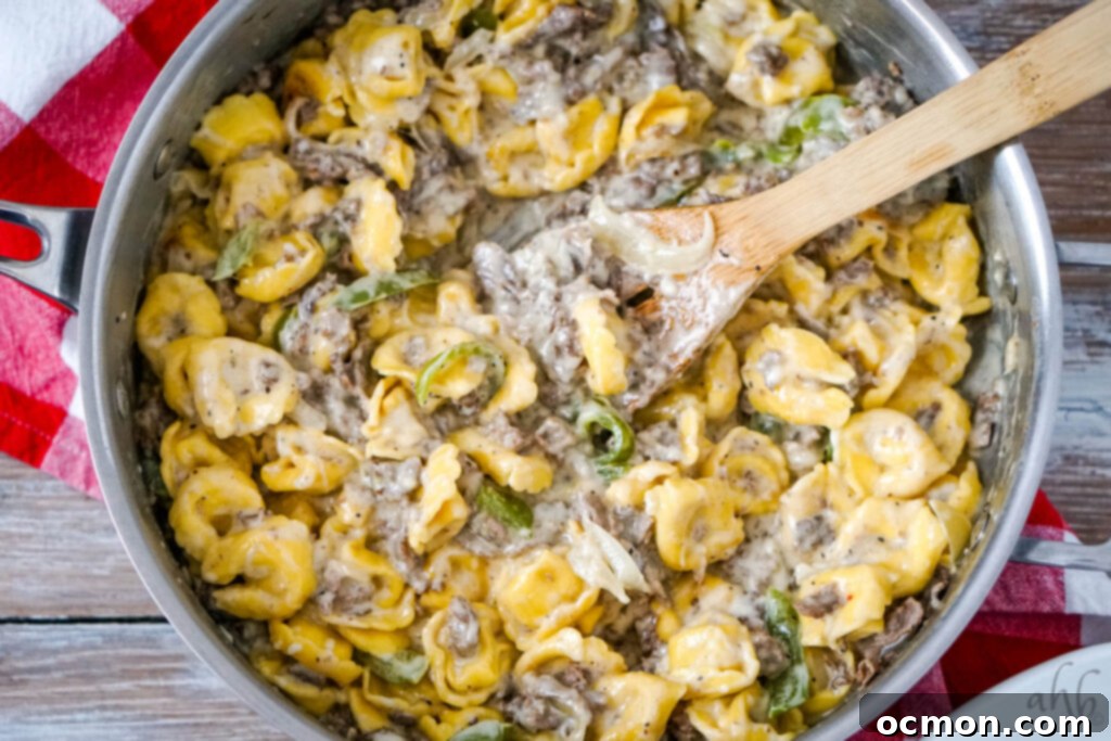 Cheesesteak Stuffed Tortellini 8 A wooden spoon sits in the sauté pan with the Philly Cheesesteak Tortellini.